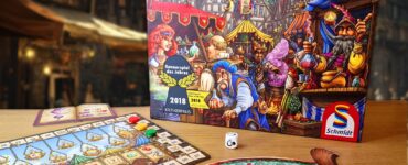 Image of the board game "The Quacks of Quedlinburg" by Wolfgang Warsch, featuring the game box, player board, and game components. The scene is set in a vibrant marketplace, showcasing colorful potions and characters. The image also includes a promotional banner for the Summer Marathon 2024 event, with the number 56 prominently displayed.