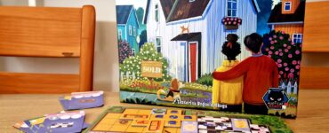 Image of the board game "Happy Home" by Matthew Dunstan and Brett J. Gilbert, featuring colorful artwork of a sold house and game pieces on a vibrant game board. The scene includes cards and tokens, with a summer marathon event label in the corner.
