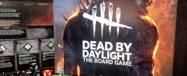 Dead by Daylight board game displayed prominently with game pieces and cards on a tabletop, featuring vibrant artwork and branding for the 2024 Summer Marathon event.