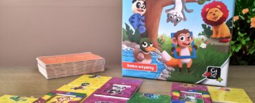 Colorful game "Zoomino" for children aged 4-7, featuring animal-themed dominoes and pairing tiles, displayed alongside the game box and additional tiles on a wooden surface, with a vibrant garden background.