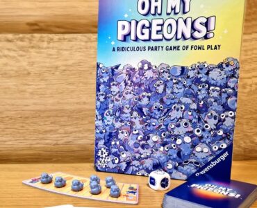 Board game "Oh My Pigeons!" by Ravensburger featuring colorful artwork, game cards, dice, and player pieces, set against a wooden background. Ideal for family game nights and parties.