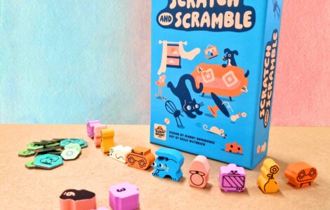 Colorful board game "Scratch and Scramble" displayed with its box and various playful tokens and pieces on a textured surface. The game features whimsical illustrations of animals and objects, making it visually appealing for family game nights.