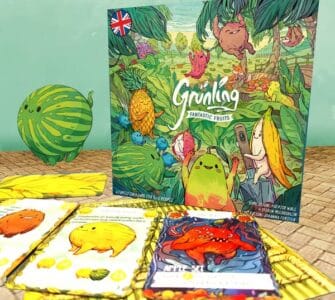 Colorful board game "Grünling: Fantastic Fruits" featuring whimsical fruit characters, surrounded by game cards and a playful watermelon illustration. Ideal for family game nights and children’s entertainment.