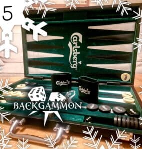 Backgammon game set featuring a green Carlsberg-themed board, dice, and game pieces, with decorative snowflakes in the background. Perfect for holiday gatherings and game nights.