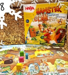 Colorful board game "Hamster Clan" by HABA displayed on a straw background, featuring game pieces and a vibrant game board, suitable for ages 4 and up.