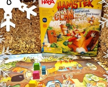 Colorful board game "Hamster Clan" by HABA displayed on a straw background, featuring game pieces and a vibrant game board, suitable for ages 4 and up.