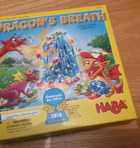 Colorful board game box of "Dragon's Breath" by HABA, featuring playful dragons and a sparkling gem theme, awarded the 2018 Children's Game of the Year.
