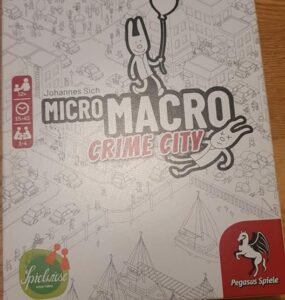 Board game box for "MicroMacro: Crime City" by Johannes Sich, featuring playful illustrations and highlighting gameplay for 1-4 players aged 12 and up, with a playtime of 15-45 minutes.