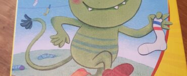 Colorful box of the children's game "Socken zocken" by HABA, featuring a cheerful green creature holding a sock, with a warning label about choking hazards.