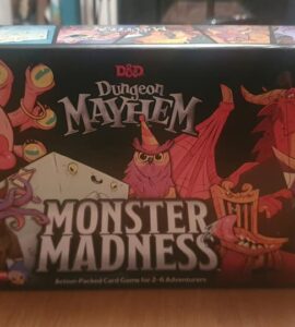 Box cover of the D&D Dungeon Mayhem: Monster Madness card game, featuring colorful cartoon-style characters like a dragon, an owl, and a whimsical creature. The game is designed for 2 to 6 players aged 8 and up, emphasizing fun and action-packed gameplay.