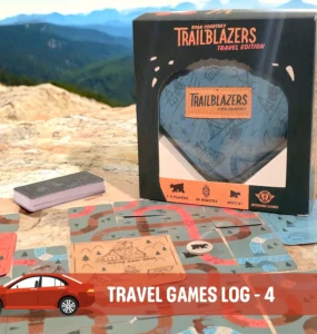 Trailblazers Travel Edition game box displayed on a rocky surface, surrounded by game cards featuring outdoor illustrations, suitable for 1-4 players and ages 8 and up. Ideal for road trips and family fun, emphasizing engagement with nature.