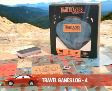 Trailblazers Travel Edition game box displayed on a rocky surface, surrounded by game cards featuring outdoor illustrations, suitable for 1-4 players and ages 8 and up. Ideal for road trips and family fun, emphasizing engagement with nature.