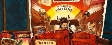 Colorful board game "K.O. Corral" displayed on a wooden table, featuring characters and a "Wanted" poster for Claude VonSnap, set in a Wild West theme with various game pieces and dice.