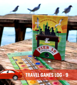Travel game log showcasing the "Pier 18" card game box on a wooden pier with seabirds in the background, highlighting outdoor gaming experiences ideal for road trips and family fun.