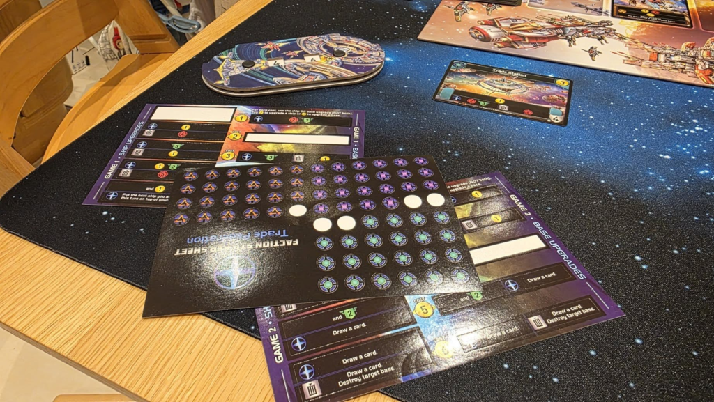 Gameplay scene featuring space-themed game boards and action cards laid out on a starry tabletop, highlighting strategic elements and player components essential for a science fiction board game session.