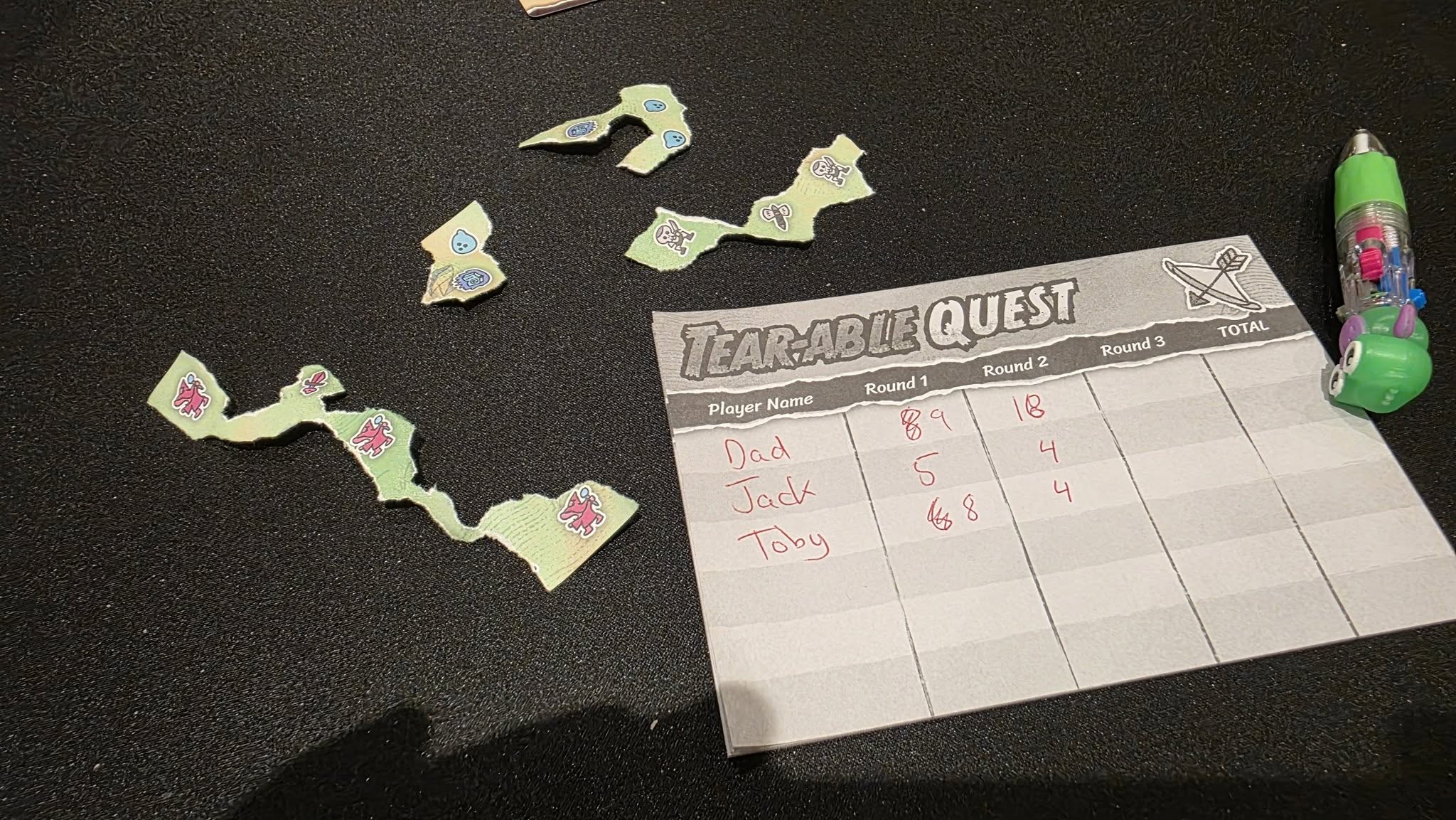 May be an image of text that says "F の堂 CEA5 中 0S5 TOTAL TEAR-ABLE QUEST Round 3 Round Round 2 Player Name B a 18 Dad 4 Jack S 4 Toby لتي 8"