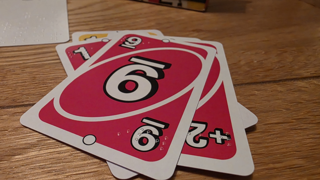 Photo of Uno cards showing the braille on them.